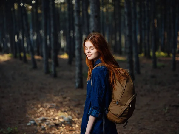 Alegre mujer pelirroja con una mochila en el bosque de viaje —  Fotos de Stock