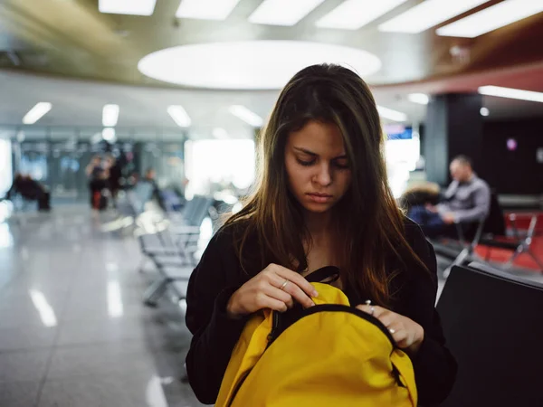 Femme assise à l'aéroport avec sac à dos jaune en attente — Photo