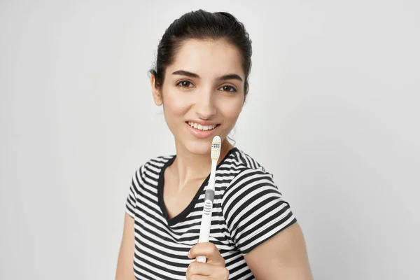 Mulher escovar os dentes com uma escova de dentes isolado fundo — Fotografia de Stock