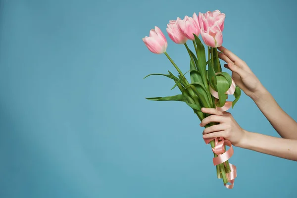 Ramo de flores de color rosa en la mano romance regalo fondo azul — Foto de Stock