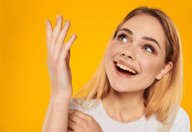 Beyaz tişörtlü güzel sarışın el hareketi stüdyo modeli yakın plan