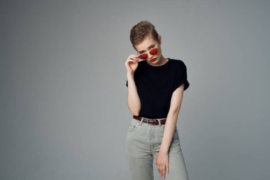 Siyah tişörtlü, siyah arka planda bir kadın.