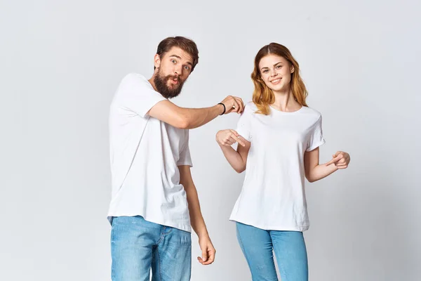 Чоловік і жінка в білих футболках студія моди позує — стокове фото