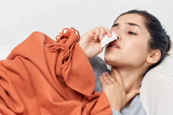 Ungesunde Frau liegt auf dem Sofa mit einer Decke bedeckt gesundheitliche Probleme — Stockfoto