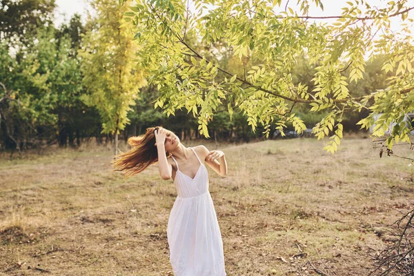 Mulher em um campo perto de uma árvore em uma natureza florestal — Fotografia de Stock