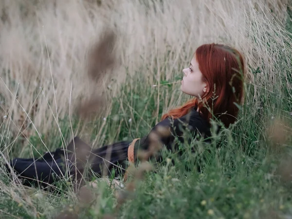 Žena na poli v přírodě leží na trávě odpočinku — Stock fotografie