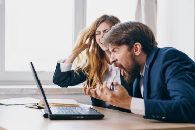 İş adamı ve kadın dizüstü bilgisayar uzmanlarının önünde oturuyor.