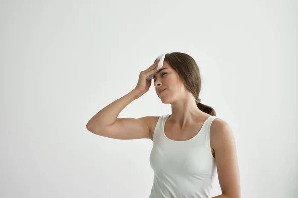 Vrouw in wit t-shirt veegt haar gezicht met een zakdoek koorts gezondheidsproblemen koud — Stockfoto