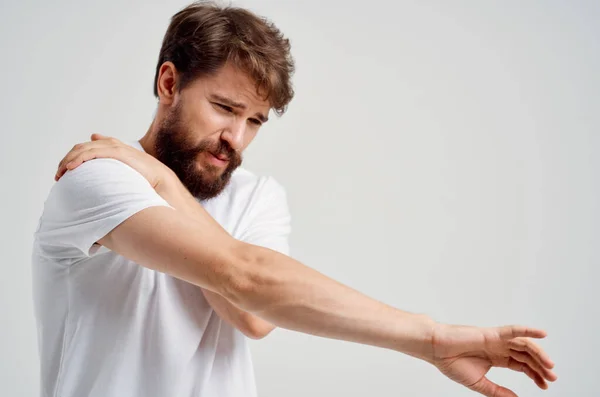 Эмоциональный мужчина в белой футболке стресс лекарство от боли в шее студийное лечение — стоковое фото
