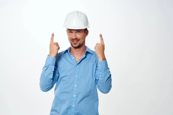 Uomo in camicia blu casco da costruzione bianco protezione ingegnere professionista — Foto Stock