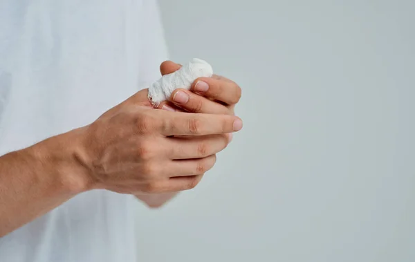 Άρρωστος άνθρωπος σε ένα λευκό T-shirt με ένα δεμένο χέρι απομονωμένο φόντο — Φωτογραφία Αρχείου