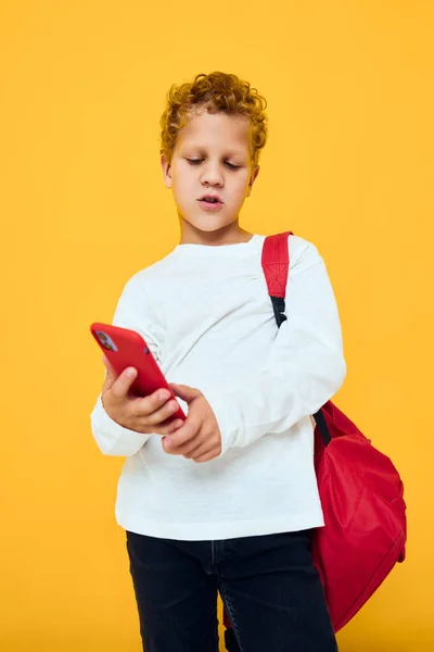 学校のバックパックと電話で話す陽気な若い男の子スタジオ学習コンセプト — ストック写真