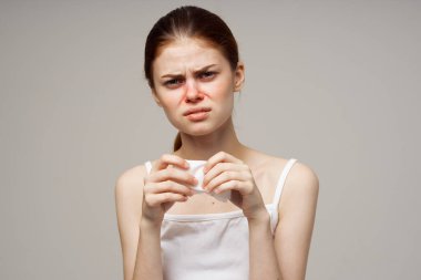 Beyaz tişörtlü, eşarplı bir kadın.