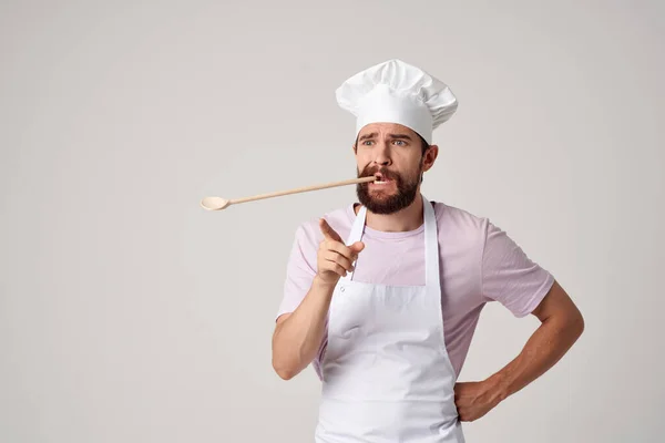 Chef masculino barbudo em colher uniforme em dentes trabalhando em um restaurante — Fotografia de Stock
