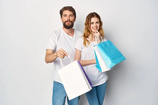 Fiatal pár fehér pólóban vásárlás szórakozás — Stock Fotó