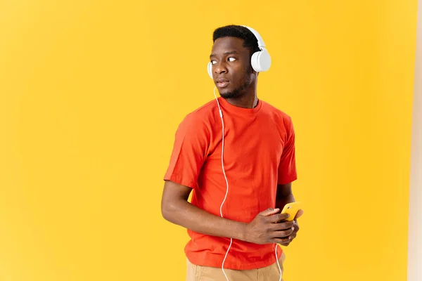 Homem em fones de ouvido com telefone na mão ouvindo entretenimento musical — Fotografia de Stock