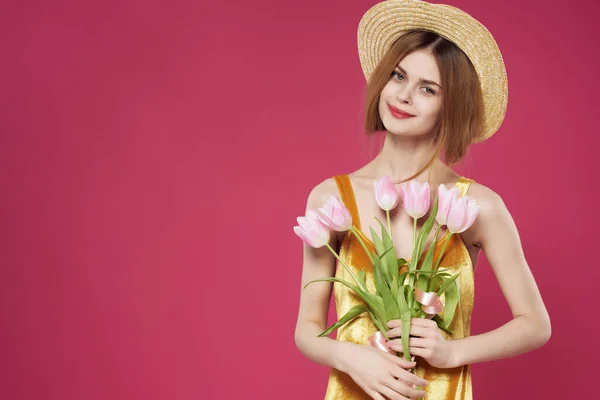 Mulher bonita no vestido com buquê de flores fundo rosa — Fotografia de Stock