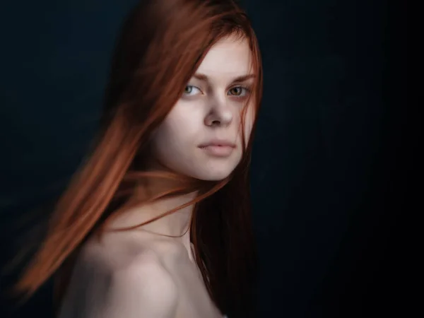 Rödhårig kvinna nakna axlar klar hud mörk bakgrund — Stockfoto