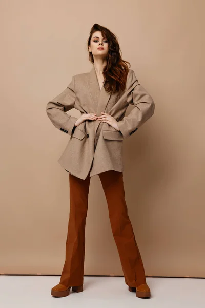 Mulher confiante modelo casaco calças e botas mantém as mãos na cintura — Fotografia de Stock