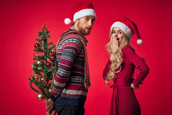 Gelukkig getrouwd stel kerstmis vakantie decoratie geschenken rood achtergrond — Stockfoto