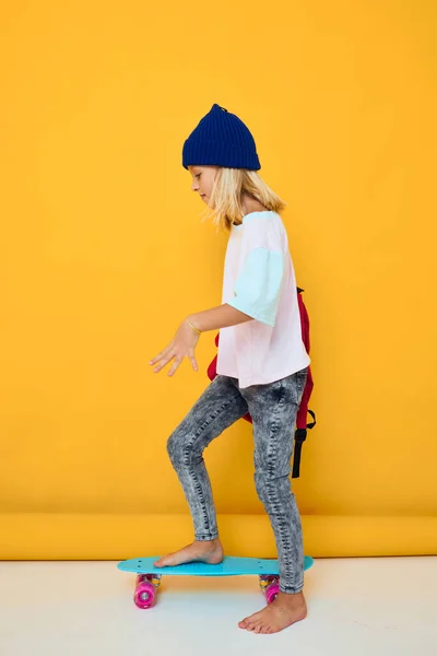 Portrét dívky jezdí na skateboardu s červeným batohem izolované pozadí — Stock fotografie