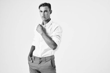 Beyaz gömlekli adam modern moda stüdyosunda poz veriyor.