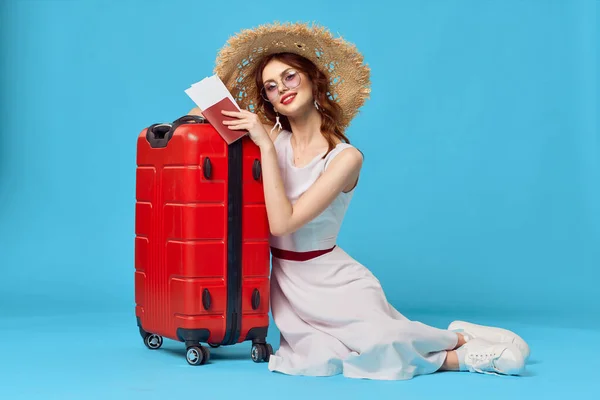 Pretty woman in hat sitting on the floor with red suitcase travel destination — Stock Photo, Image