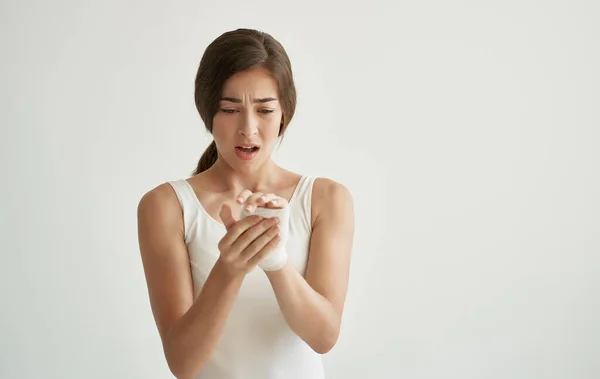 Mujer en camiseta blanca tratamiento medicamentos problemas de salud fondo claro — Foto de Stock