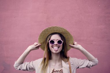 Güzel bir kadın, dışarıda yürüyor. Moda, yaz, pembe duvar gezisi.