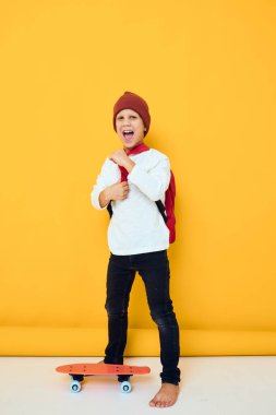 Beyaz süveterli kaykaylı şirin çocukların portresi. Çocukluk hayatı konsepti.