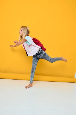 Küçük kız şık kıyafetler kırmızı sırt çantası izole edilmiş arka plan