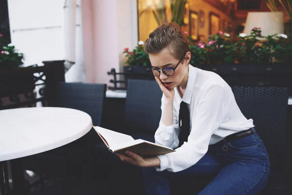 Femme aux cheveux courts avec un livre dans ses mains lecture éducation — Photo