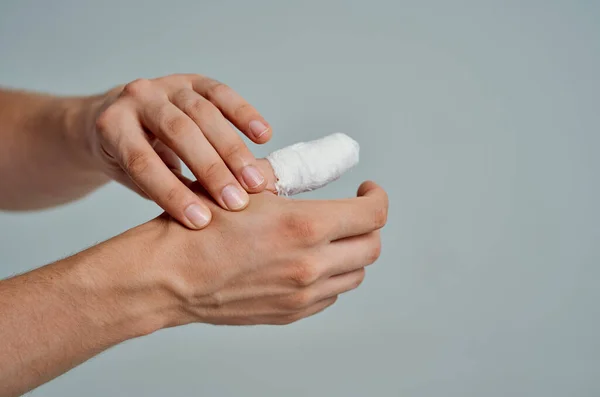 Paciente masculino con una camiseta blanca con una medicina de hospital de mano vendada —  Fotos de Stock