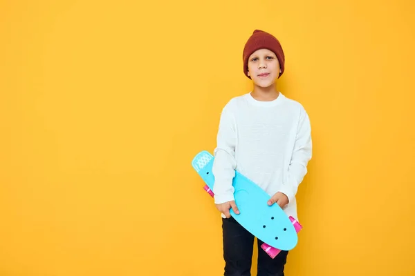 쿨 한 미소를 짓는 멋진 소년 평범 한 파란 스케이트 보드 스튜디오 포즈 — 스톡 사진