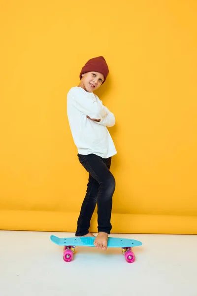 Portrét roztomilých chlapců v bílém svetru skateboard zábavní studio pózování — Stock fotografie