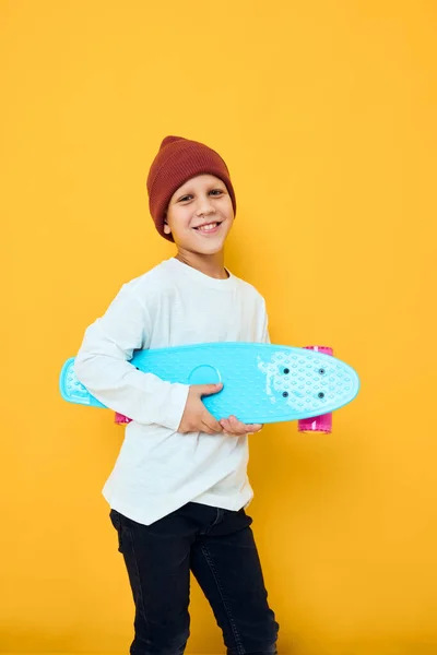 Смешной маленький мальчик в белом свитере скейтборд развлечения изолированный фон — стоковое фото
