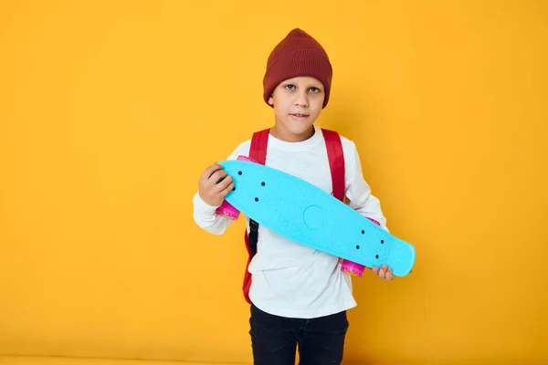 Portret van leuke jongens met rode rugzak blauw skateboard studio lifestyle — Stockfoto