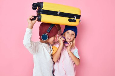 komik küçük çocuk ve kız tatil için hazırlanıyor genç gezginler pembe renkli arka plan