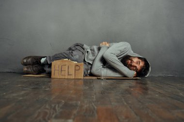 Dilenci adam yerde yatıyor evsiz bunalımı para sorunlarına yardım ediyor.