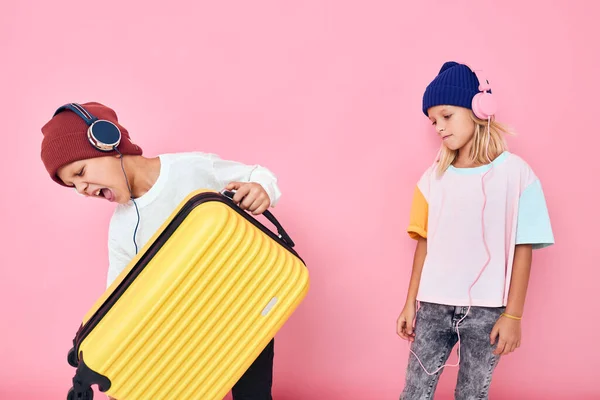 Χαριτωμένο χαμογελαστά παιδιά κομψό ρούχα βαλίτσα ακουστικά στούντιο θέτουν — Φωτογραφία Αρχείου