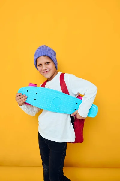 赤いバックパックの青いスケートボードと笑顔の学校の男の子子供のライフスタイルコンセプト — ストック写真