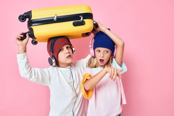 손에 노란 가방을 든 귀여운 꼬마들 이 스튜디오에서 포즈를 취하는 모습 — 스톡 사진