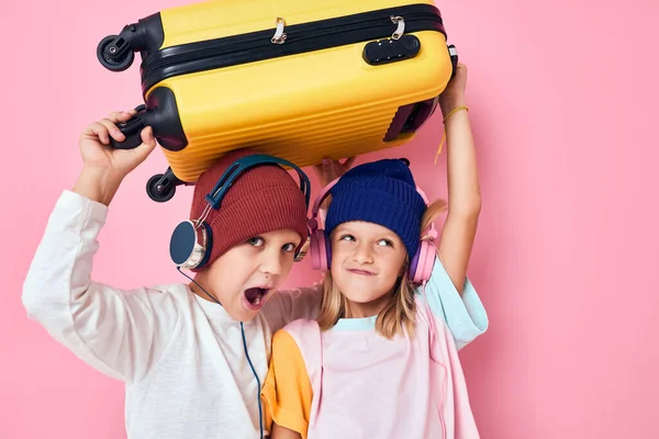 미소짓는 귀여운 아이들, 헤드폰 핑크 색 옷 가방을 입고 노는 모습 — 스톡 사진