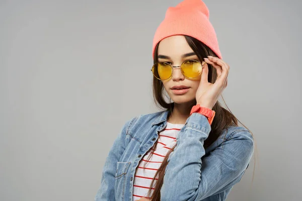 Nő sárga szemüveg rózsaszín kalap divat modern stílus szürke háttér — Stock Fotó