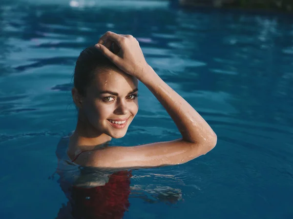 Весёлая женщина в купальнике в бассейне улыбается, расслабляет природу — стоковое фото