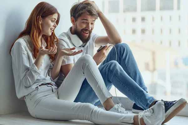 Um jovem casal conversando perto da janela romance alegria tecnologia — Fotografia de Stock