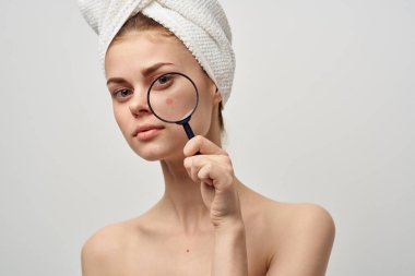 Güzel bir kadın, elinde büyüteçle hijyen tedavisi görüyor.