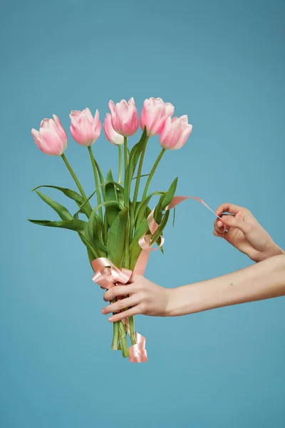Ramo de flores de color rosa en la mano romance regalo fondo azul — Foto de Stock