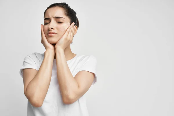 Mujer sosteniendo su cabeza traumatismo problemas de salud luz fondo — Foto de Stock