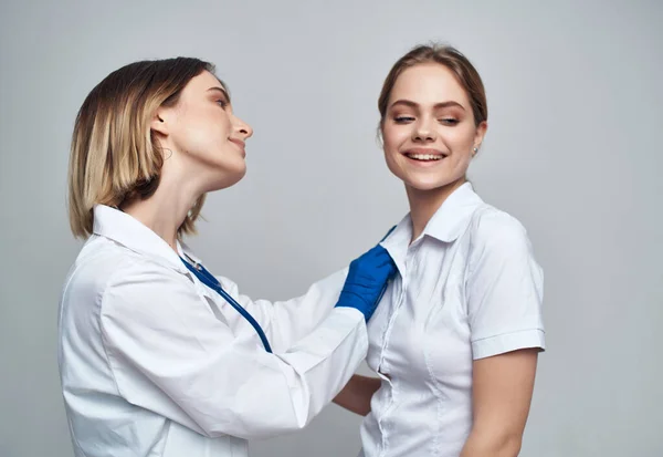 Женщины врач стетоскоп лечебные процедуры легкий фон — стоковое фото